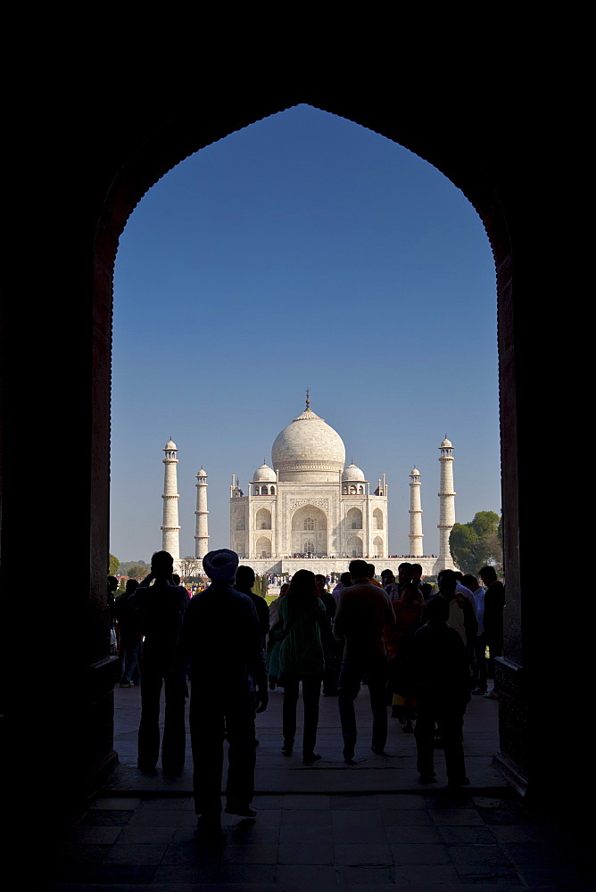 Crowd of tourists framed by The Great Gate, Darwaza-i rauza, of The Taj Mahal view southern aspect, Uttar Pradesh, India