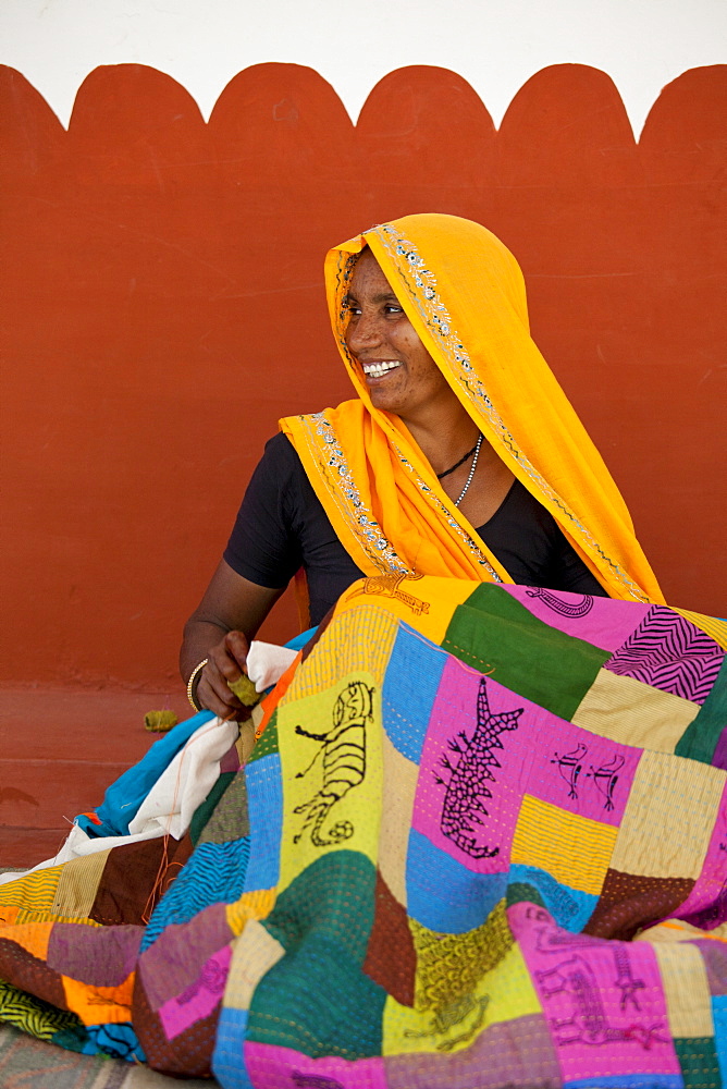 Indian woman sewing textiles at Dastkar women's craft co-operative, the Ranthambore Artisan Project, in Rajasthan, Northern India