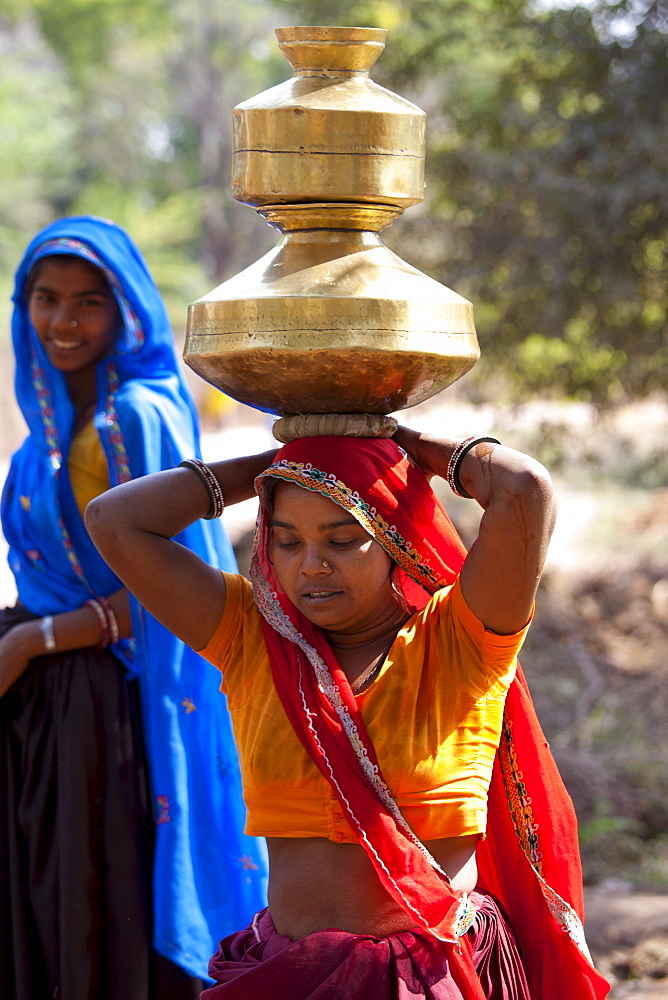 Indian woman carrying water pots on her head at Sawai Madhopur in Rajasthan, Northern India