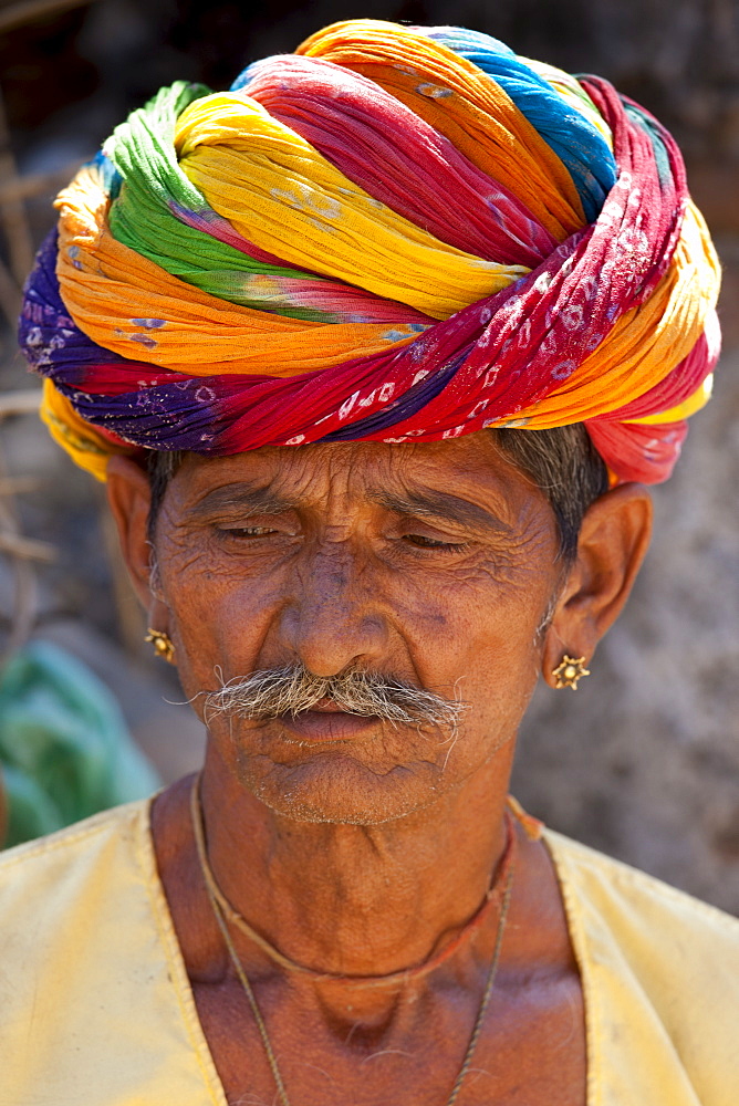 Indian man wearing traditional Rajasthani turban and gold earring in village of Nimaj, Rajasthan, Northern India