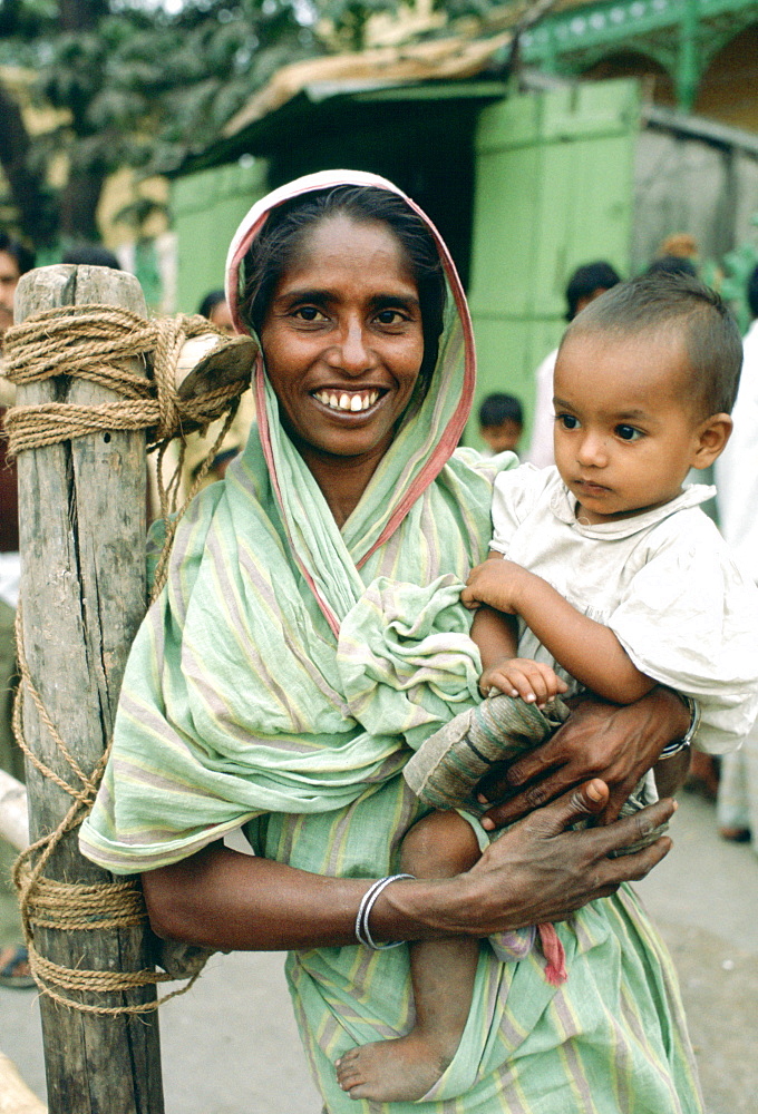 Mother holding child, street scene, India