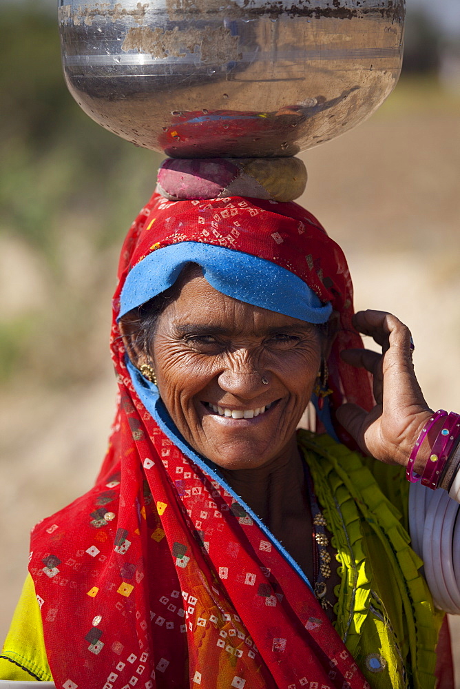 Indian Bishnoi woman carrying water pot near Rohet in Rajasthan, Northern India