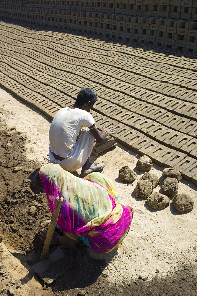 Indian family forming bricks made from mud clay at Khore Bricks Factory, Rajasthan, Northern India