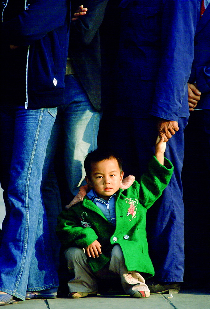 Child in a queue waiting to enter the Forbidden City in Beijing, China