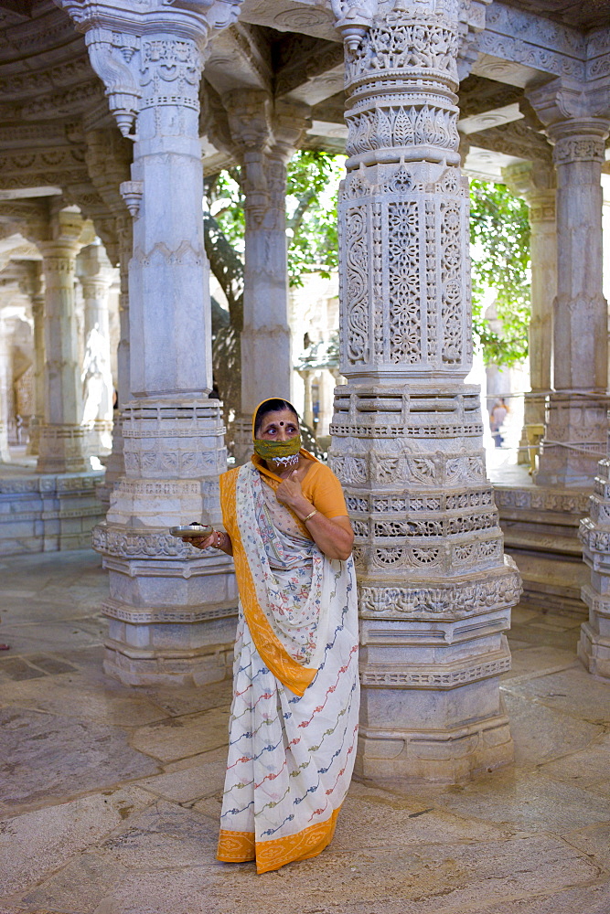 Jain pilgrim with traditional mask at The Ranakpur Jain Temple at Desuri Tehsil in Pali District, Rajasthan, India