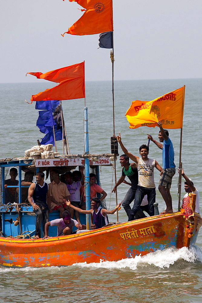 Young Indian men on boat trip celebrating Hindu Holi festival of colours at Nariman Point, Mumbai, formerly Bombay, India