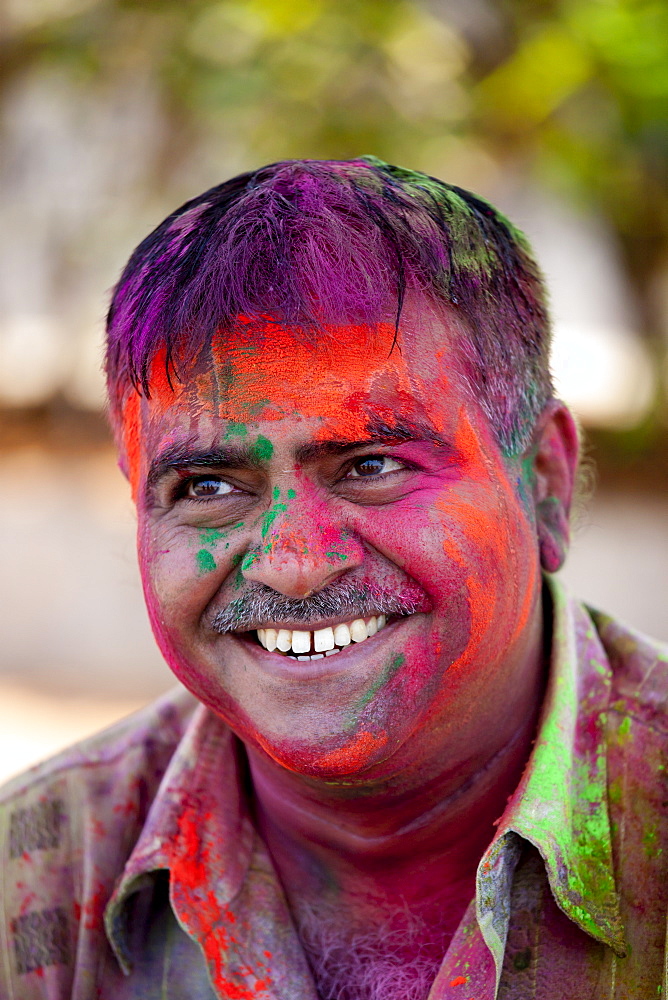 Indian man celebrating annual Hindu Holi festival of colours with powder paints in Mumbai, formerly Bombay, Maharashtra, India