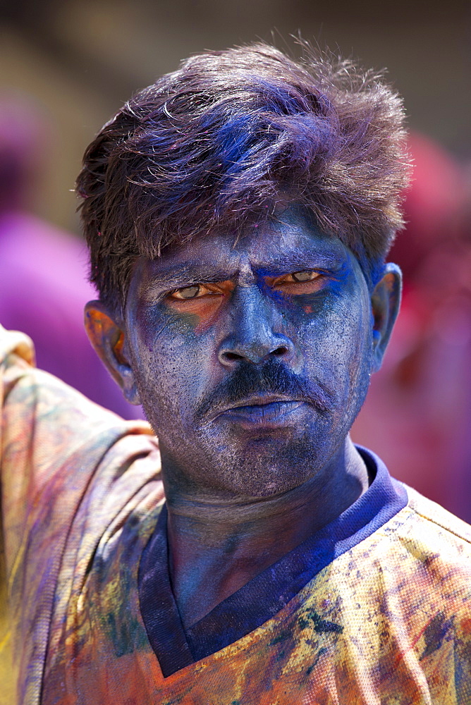 Indian man celebrating annual Hindu Holi festival of colours smeared with powder paints in Mumbai, formerly Bombay, Maharashtra, India