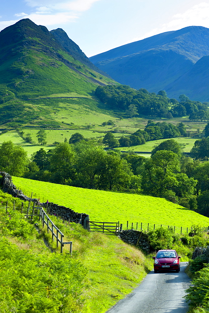 Motoring holiday tourists driving through Cumbrian mountain range near Derwentwater in Lake District National Park, UK