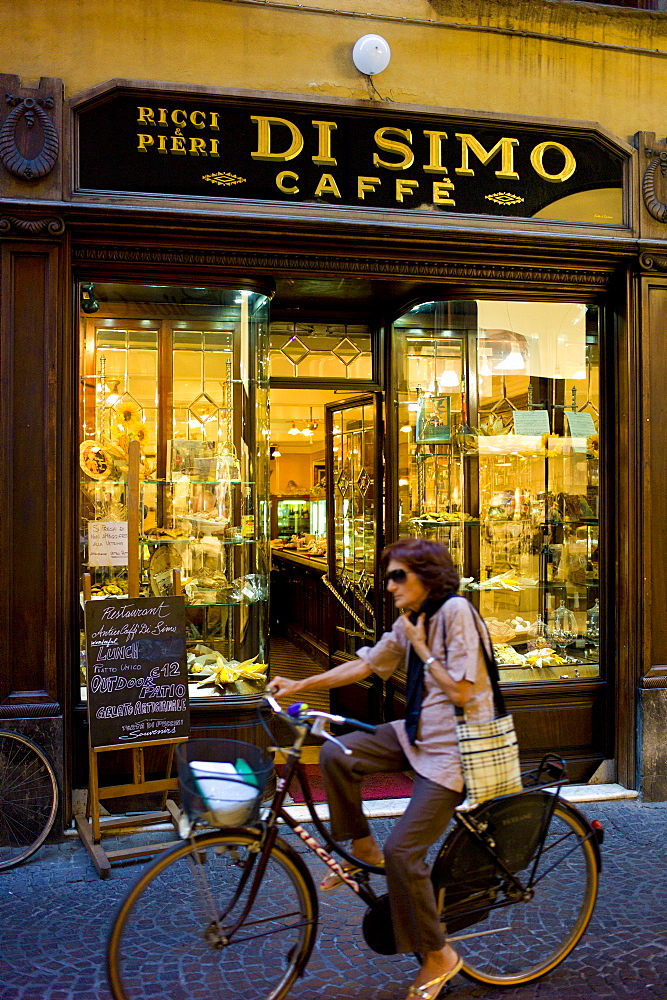 Cyclist passing Di Simo Caffe, Ricci and Pieri, in Via Fillungo,  Lucca, Italy