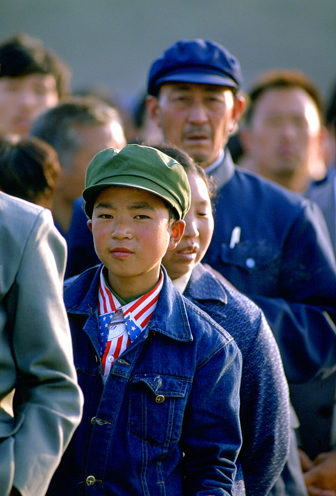 Chinese boy wearing a patriotic American stars and stripes shirt and denim jacket queues to enter the Great Hall of the People  in Tiananmen Square, Beijing, China