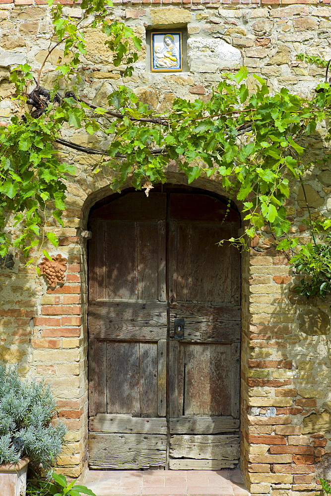 Ancient doorway and religious painting at Il Rigo agritourismo hotel and farmhouse, San Quirico d'Orcia, in Val D'Orcia area Tuscany, Italy