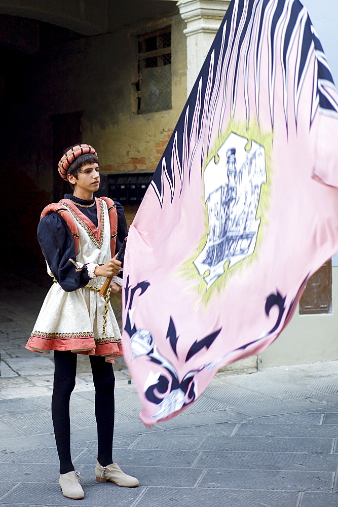 Contrada young man in livery costume at traditional parade in Asciano, inTuscany, Italy