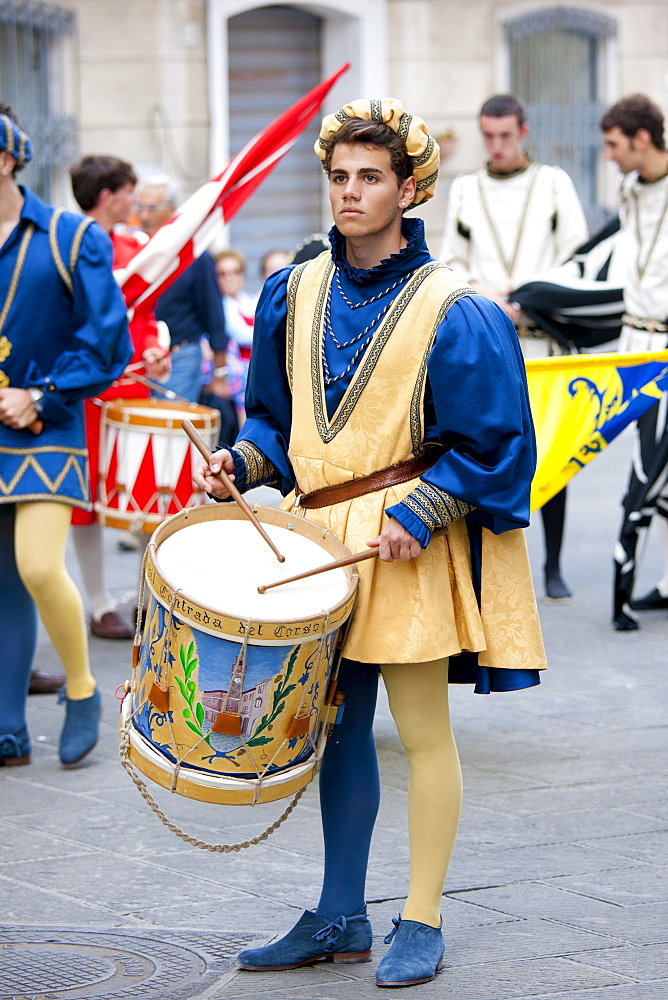 Contrada members in livery costumes for traditional parade in Asciano, inTuscany, Italy