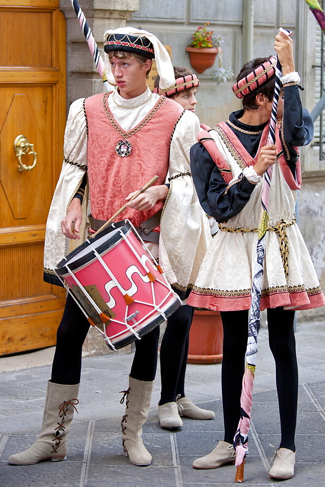 Contrada members in livery costumes for traditional parade in Asciano, inTuscany, Italy