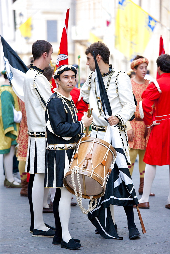 Contrada members in livery costumes for traditional parade in Asciano, inTuscany, Italy