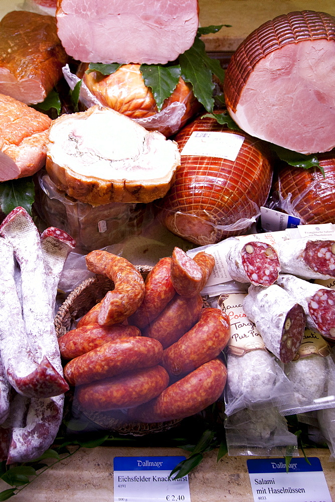 Shop display of cured meats, hams, pork sausages, salami, at Dalmayr food shop and delicatessen in Munich, Bavaria, Germany