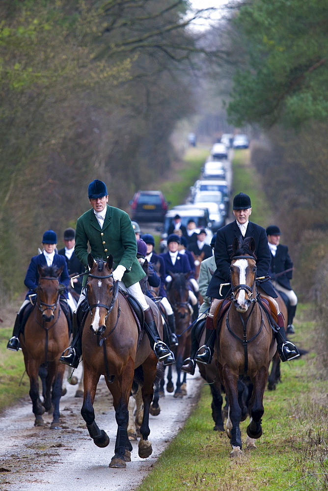 Members of the Heythrop Hunt, hunt official wearing green jacket, at a meet in Swinbrook in The Cotswolds, Oxfordshire, United Kingdom