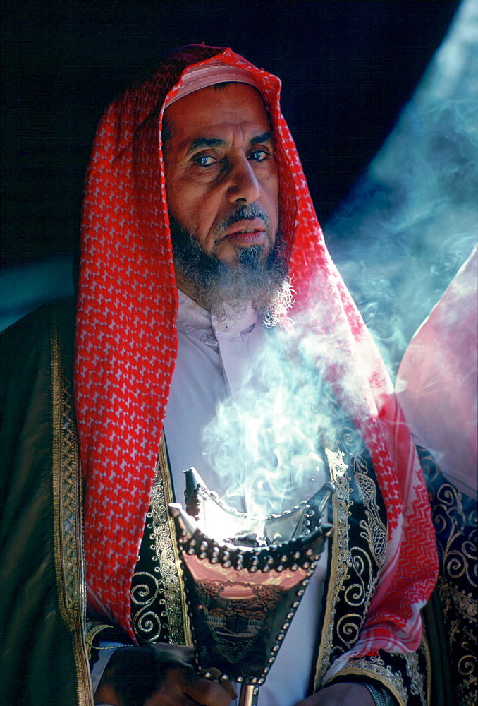 A Bedouin man in his tent holding an incense burner in Riyadh, Saudi Arabia