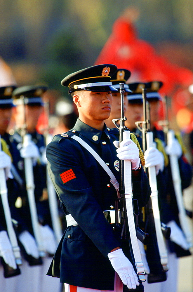 Soldiers on parade in South Korea raise their rifles