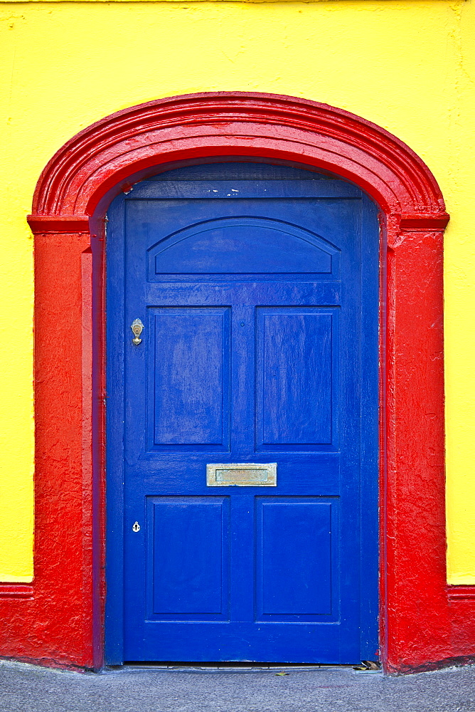 Brightly coloured red blue doorway yellow wall of Furlong's Bar in Passage East, Co. Waterford, Ireland