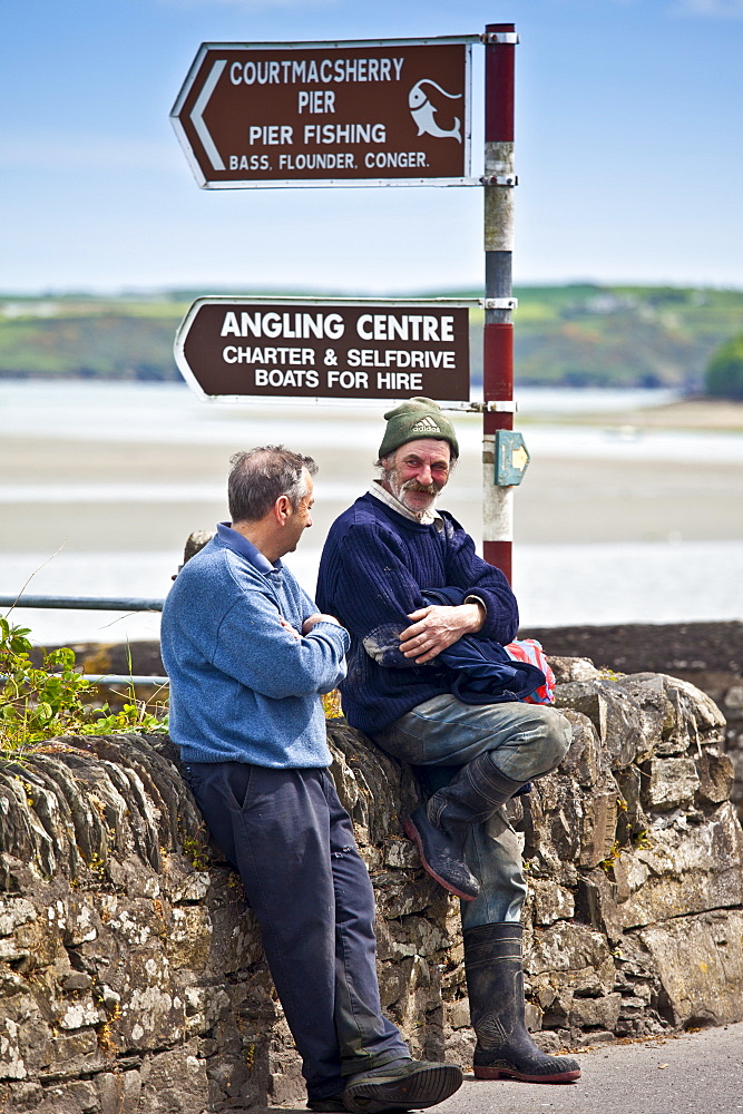 Locals chatting in the Gaelic language on the quayside at Courtmacsherry in County Cork, Ireland