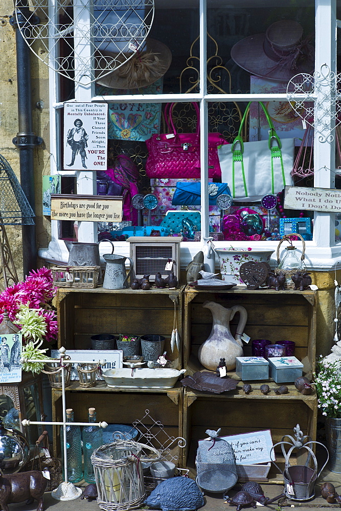 Tourist leaving curiosity shop selling souvenirs, collectibles and gift items in Chipping Campden, The Cotswolds, UK