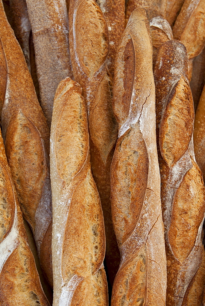 Freshly-baked French bread baguettes on sale at food market in Bordeaux region of France