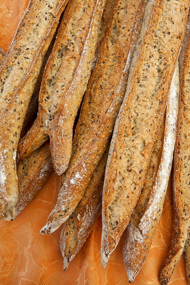 Freshly-baked multigrain French bread baguettes on sale at food market in Bordeaux region of France