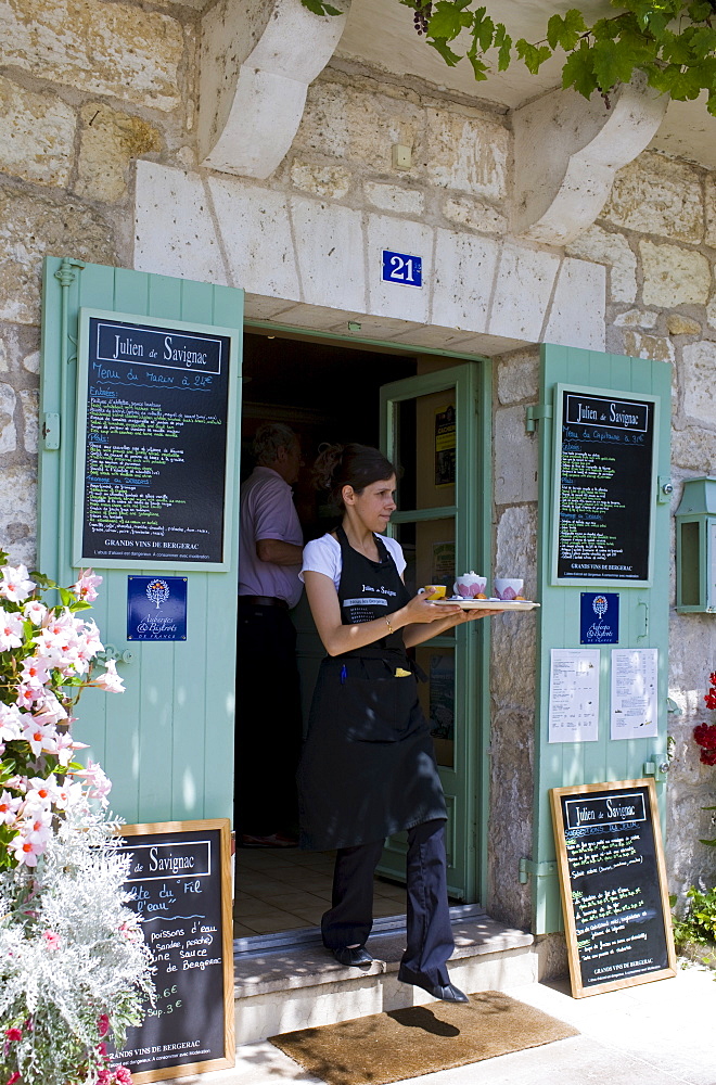 Waitress serving at French outdoor cafe in tourist town Brantome in the Northern Dordogne, France