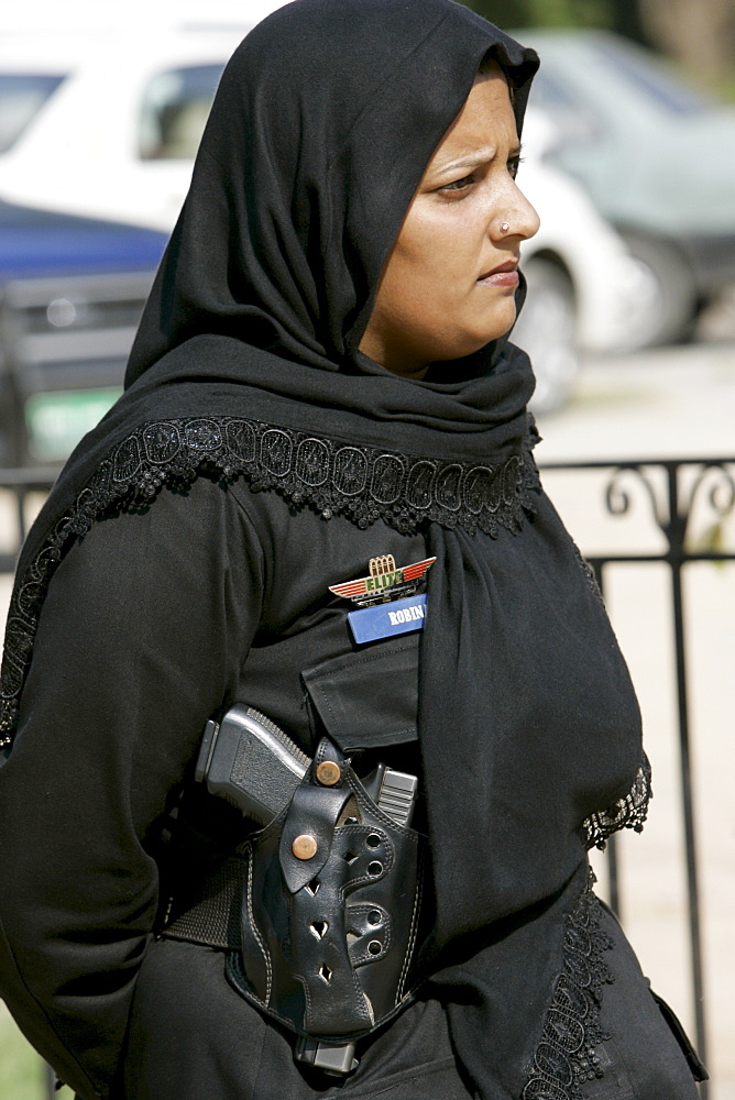 Female armed police officer with hijab and gun in holster in Rawalpindi, Pakistan