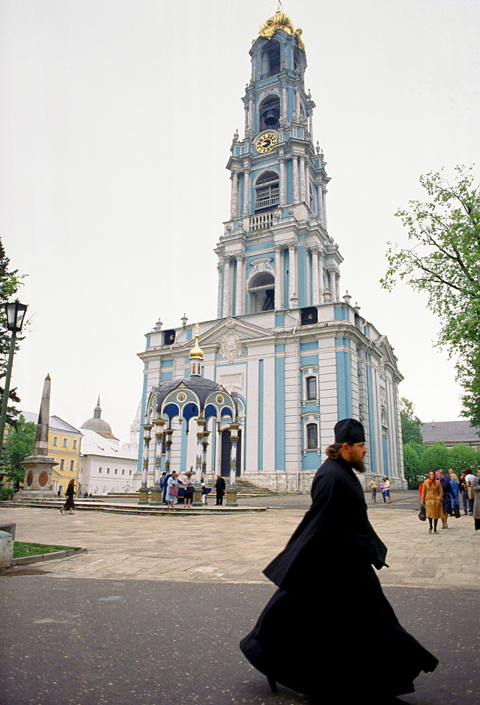 Monk and bell tower of Trinity Lavra of St Sergius, Russian Orthodox monastery at Sergiyev Posad, Zagorsk, near Moscow, Russia