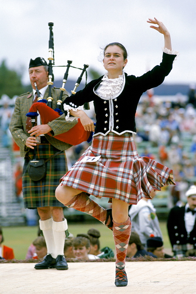 Scottish girl in tartan kilt dancing traditional dance at the Braemar Royal Highland Gathering, the Braemar Games in Scotland