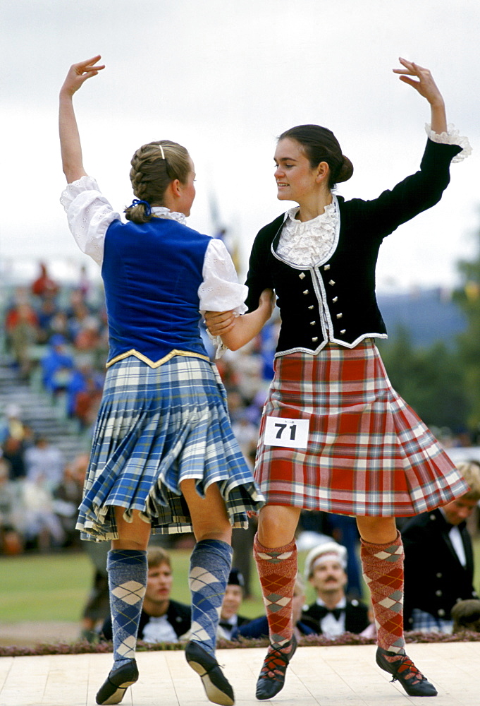 Scottish girls in tartan kilts dancing traditional dance at the Braemar Royal Highland Gathering, the Braemar Games in Scotland