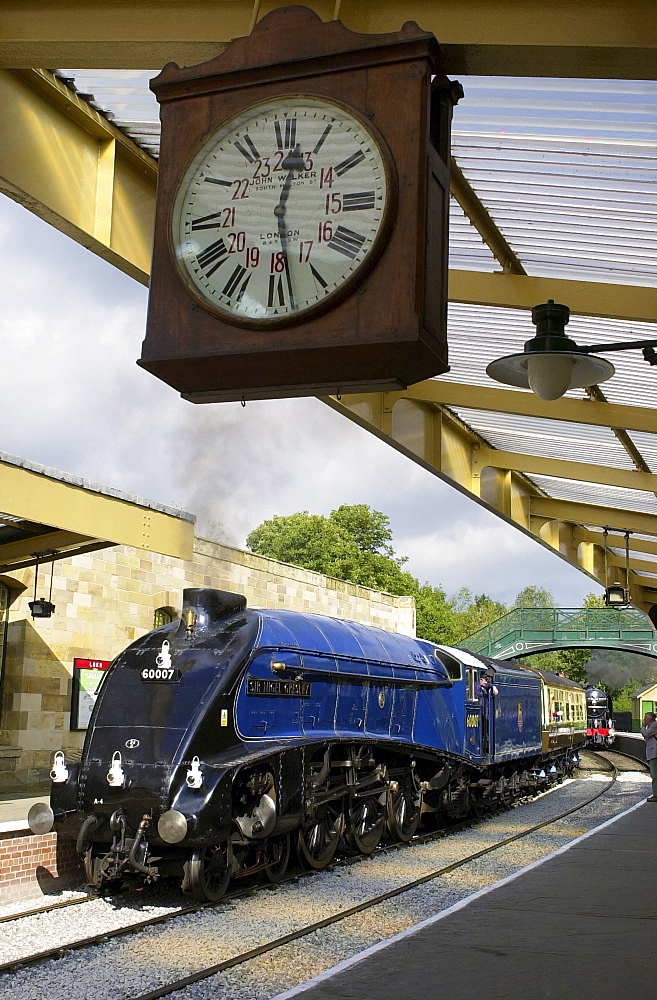 Sir Nigel Gresley A4 Pacific steam engine locomotive and train carriages at Pickering Railway station platform, Yorkshire, England, UK