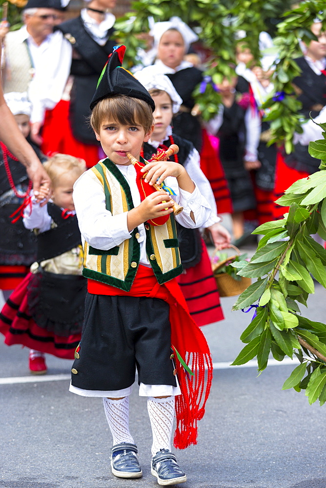 Spanish boy playing musical instrument at traditional fiesta at Villaviciosa in Asturias, Northern Spain, Europe