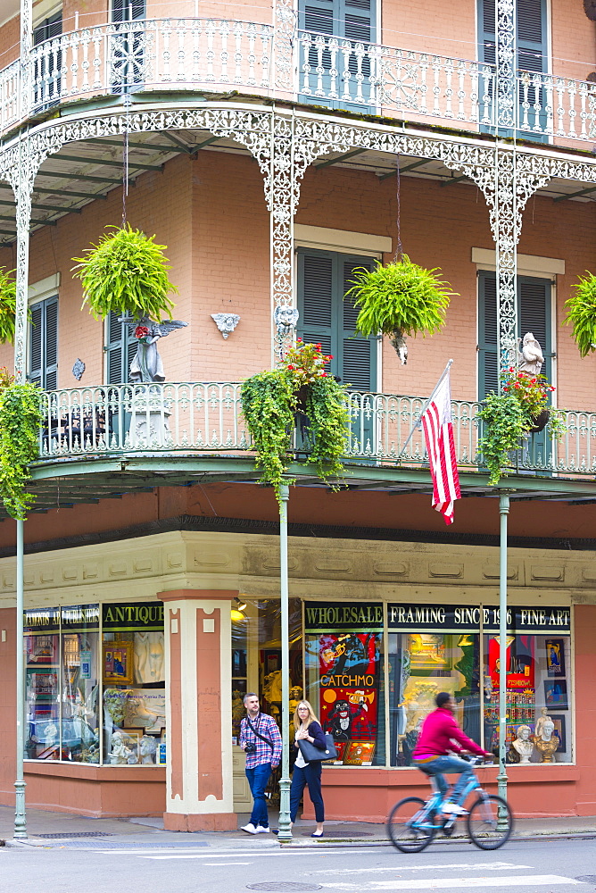 Tourists, typical architecture, wrought iron balcony and flag corner St Philip and Royal Street, French Quarter, New Orleans, USA