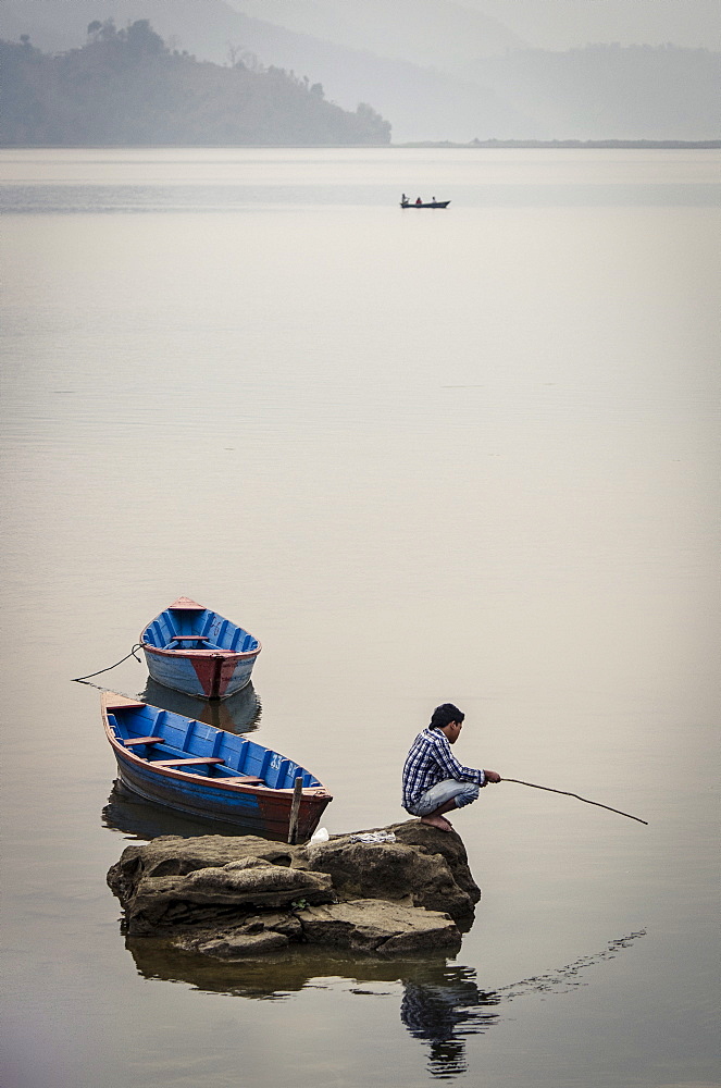 A man fishing on Phewa Tal (Phewa Lake), Pokhara, Nepal, Asia 