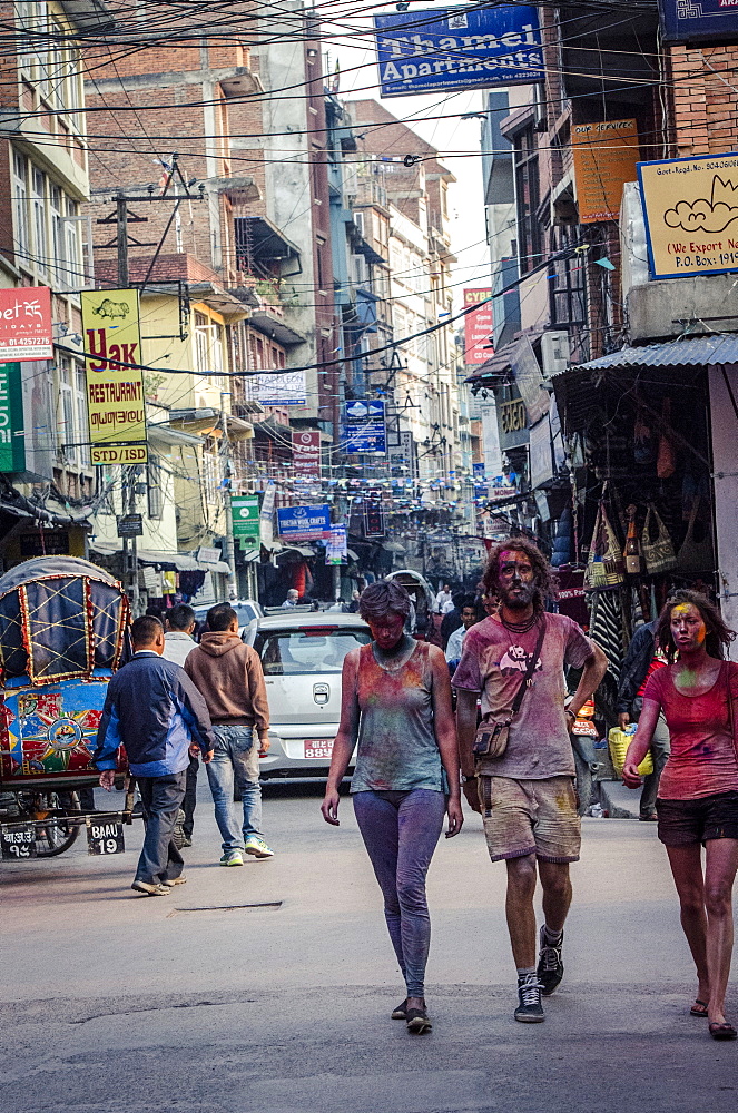 Westerners covered in coloured powder during Holi festival celebrations, Basantapur Durbar Square, Kathmandu, Nepal, Asia 