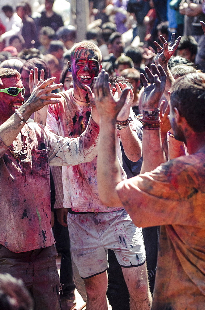 Westerners covered in coloured powder during Holi festival celebrations, Basantapur Durbar Square, Kathmandu, Nepal, Asia 