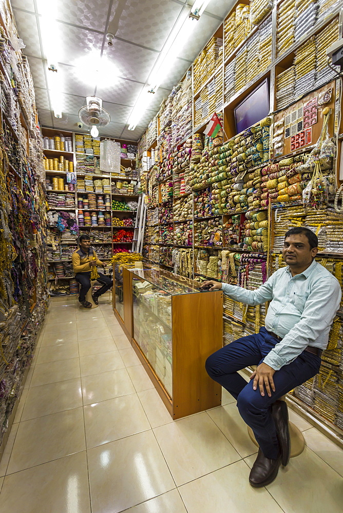 Seated shopkeepers in a brocade shop at Mutrah Souq, Muscat, Oman, Middle East