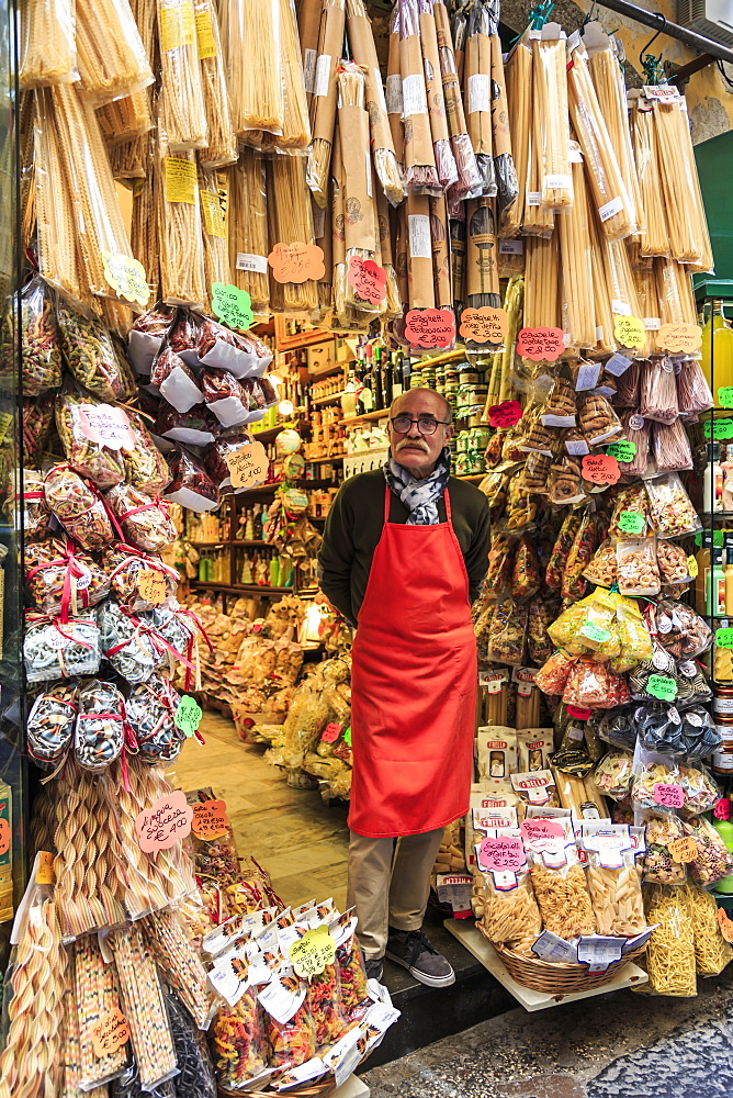 Grocery store owner proudly stands at shop front with pasta, City of Naples Historic Centre, UNESCO World Heritage Site, Naples, Campania, Italy, Europe