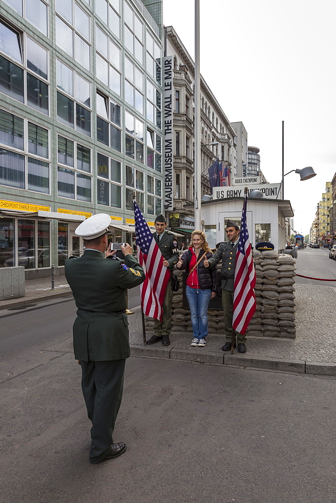 Tourist has photo taken with uniformed actor border guards, Checkpoint Charlie, Mitte, Berlin, Germany, Europe