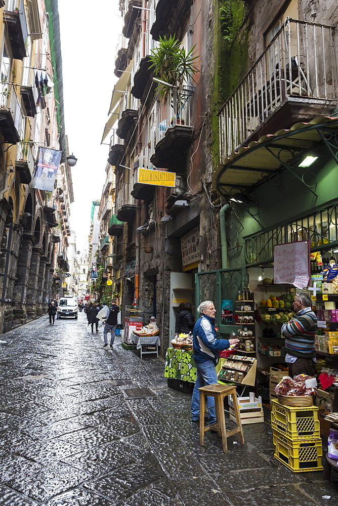 Shopkeeper and customer in wet narrow street, Historic Centre (Centro Storico), UNESCO World Heritage Site, Naples, Campania, Italy, Europe