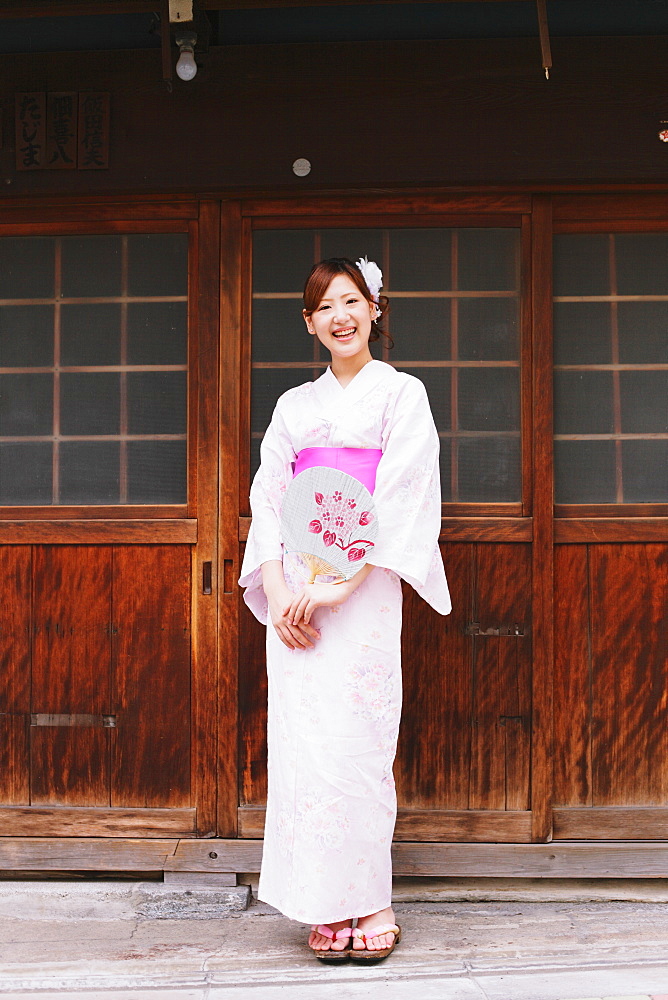 Japanese woman in Yukata holding a traditional paper fan