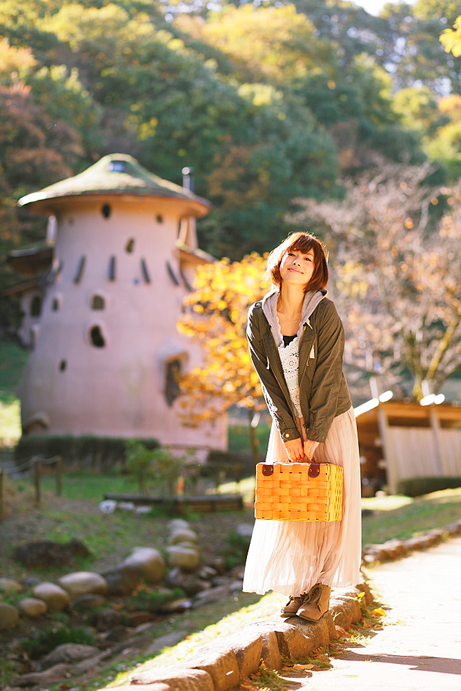 Japanese woman with short hair holding a basket and looking at camera