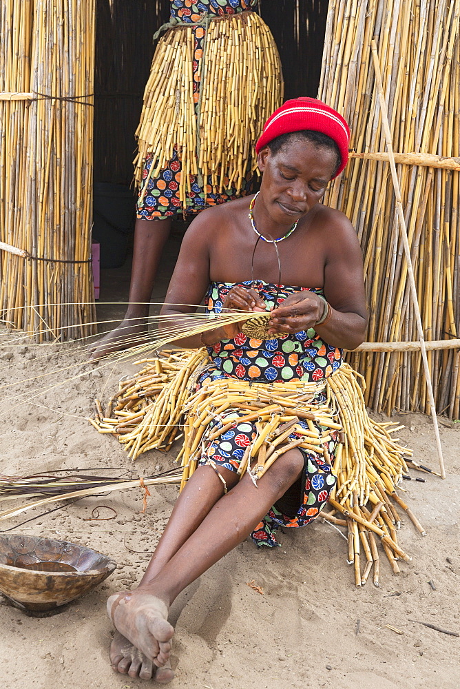 At the visitor village Lizauli you can gain an insight into the traditional way of life of the Mbukushu, Caprivi Region, Namibia - here a woman weaving raffia