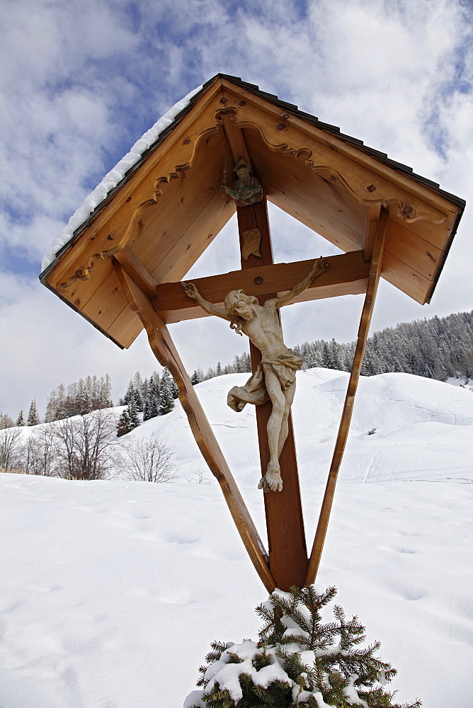 Close-up of shrine with crucifix in snow, South Tyrol, Italy