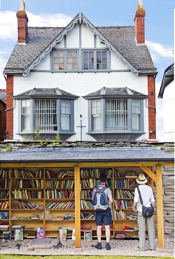 Men at outside bookstore in Hay-on-Wye village, Powys, Wales, UK