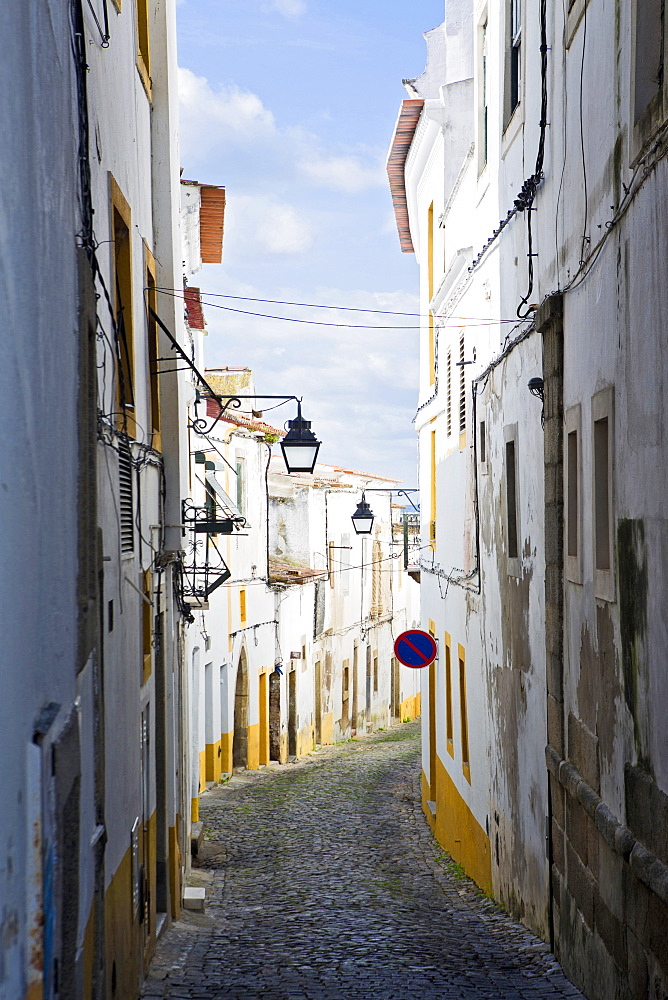 View along the medieval cobbled street of Rua do Moeda in historic centre of Evora, UNESCO World Heritage Site, Alentejo, Portugal, Europe